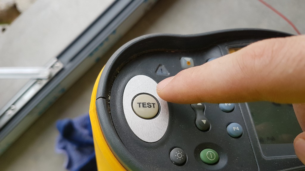PAT Testing machine with man about to press the test button