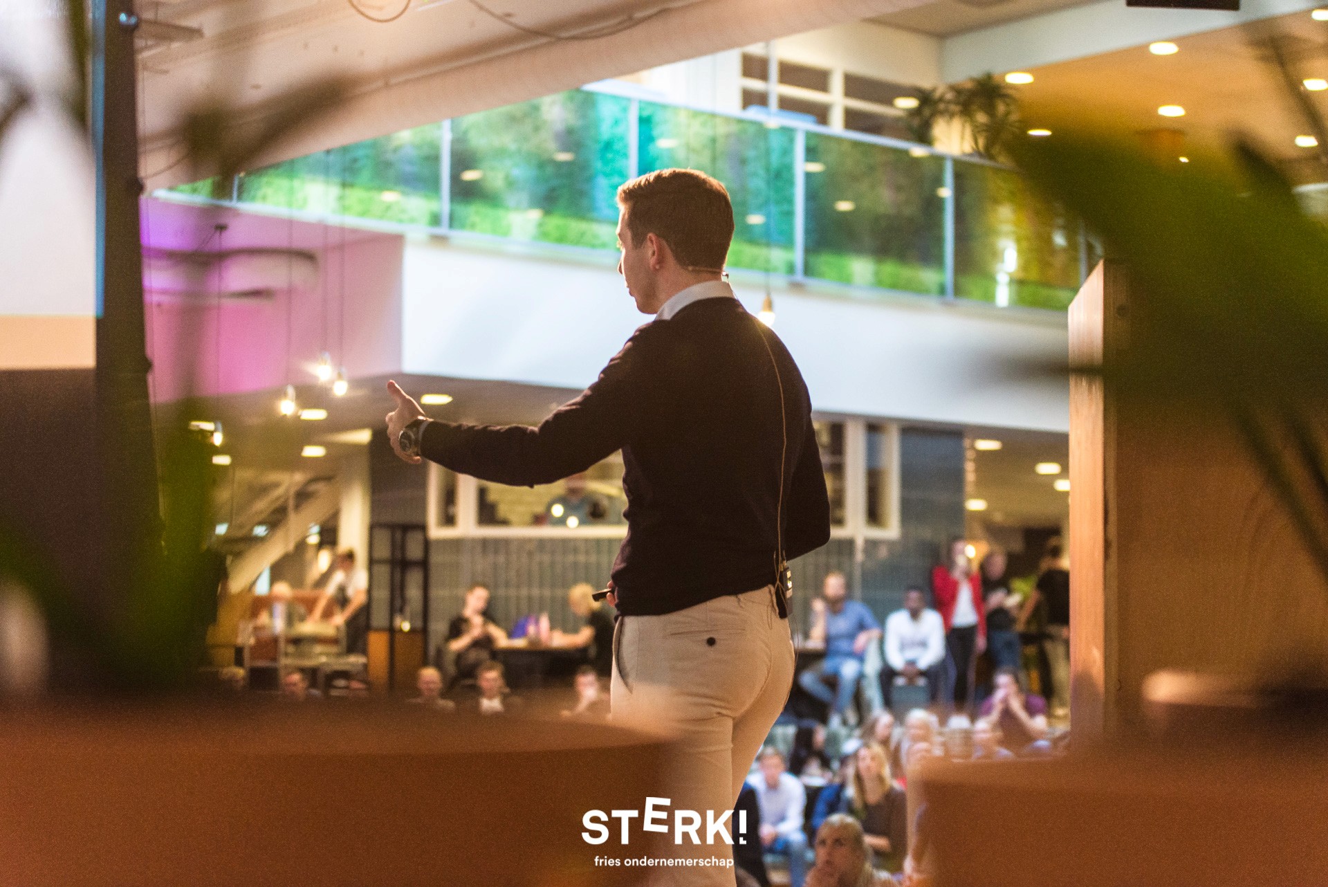 Close-up of a dark green leaf showing its textured surface and central vein against a muted background.