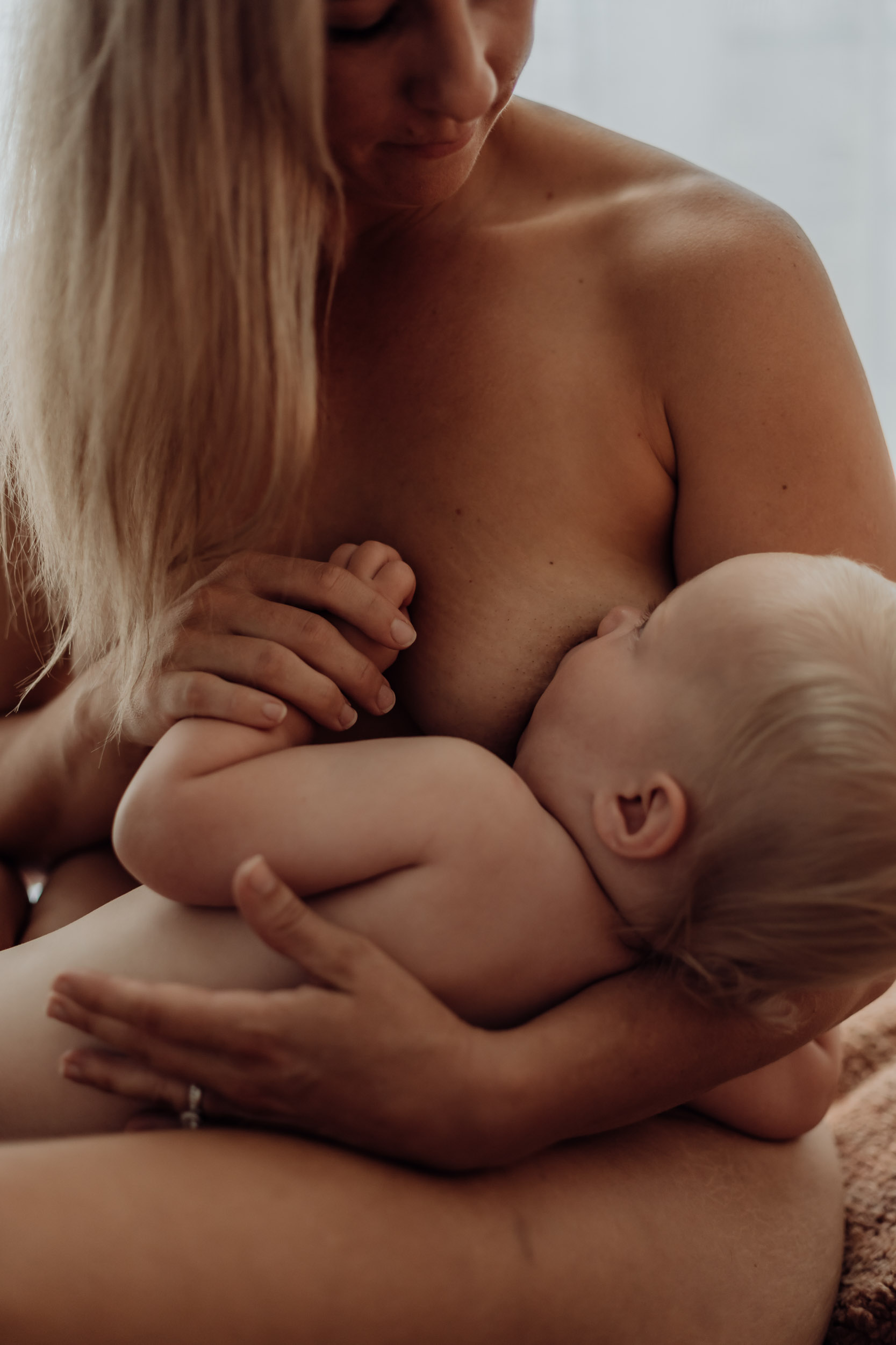 Tender moment of a mother nursing her baby captured during a natural motherhood photography session in Mackay
