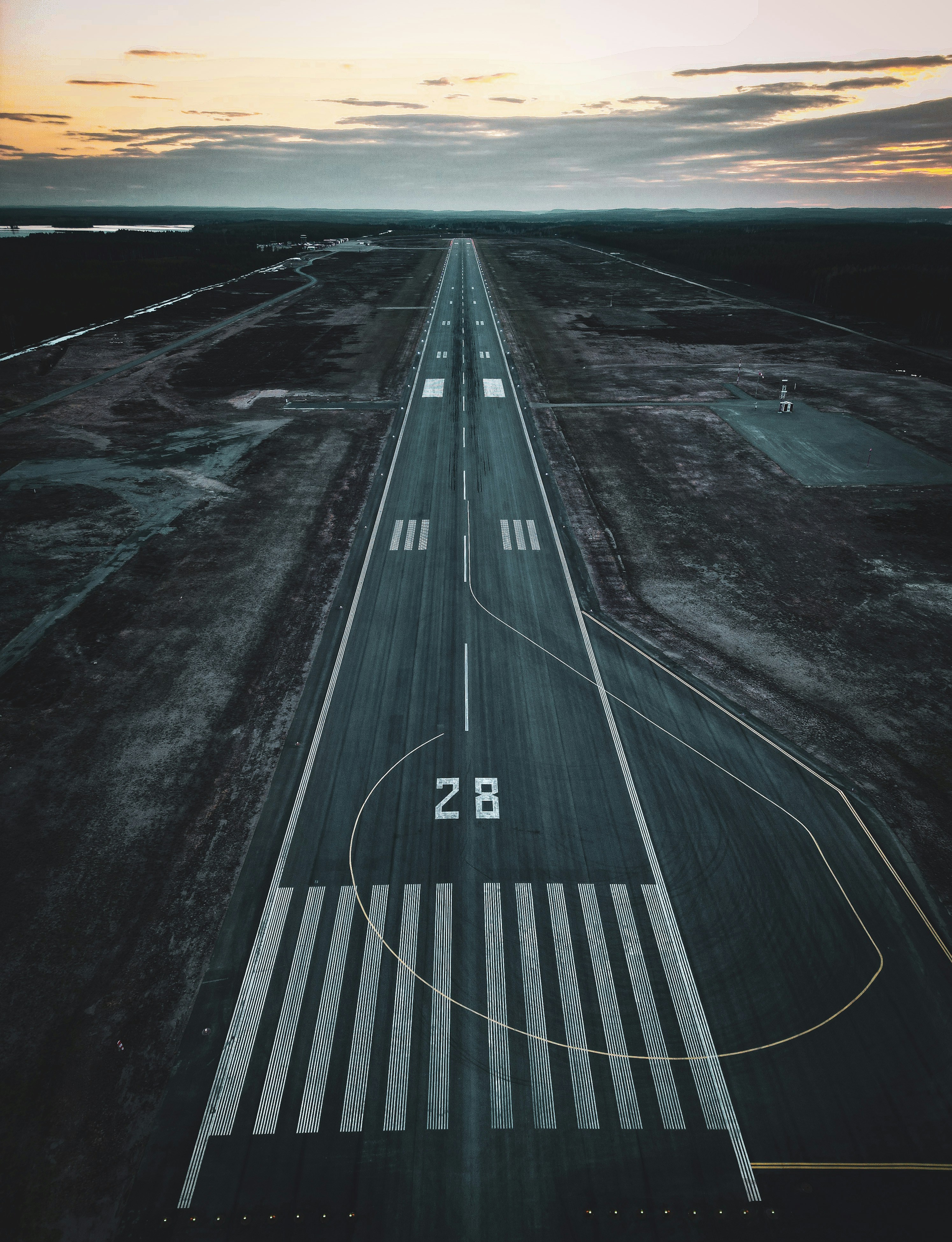 an aerial view of an airport runway at sunset