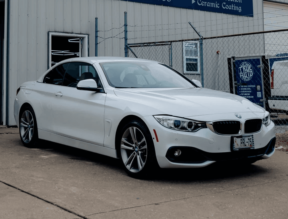 white BMW out front of a shop