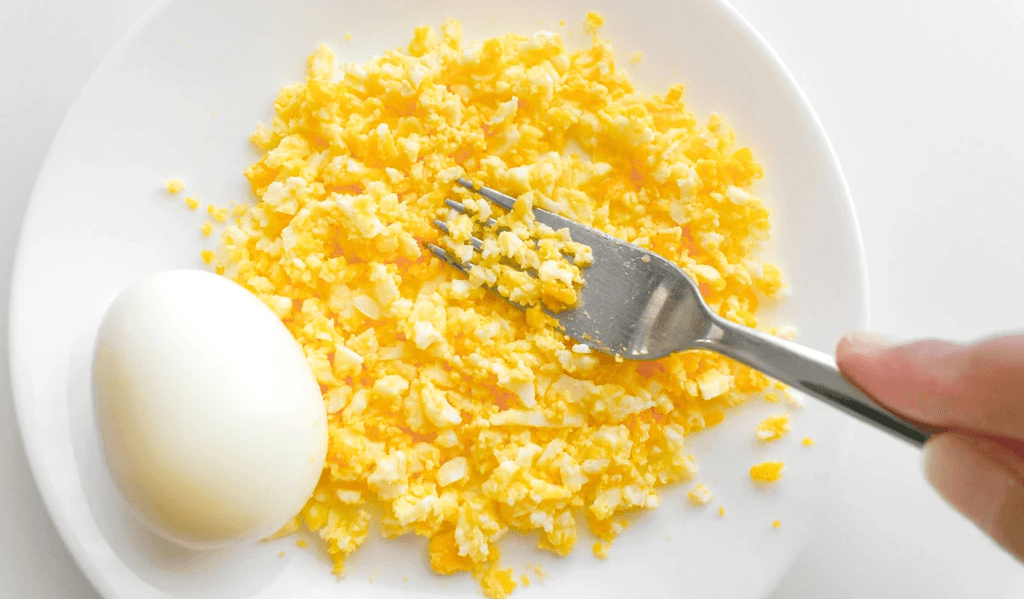 Halved Boiled Eggs with Fork on White Plate