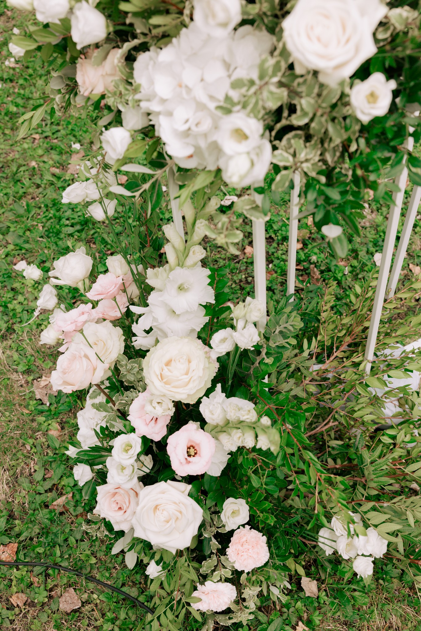Decorazione floreale con rose bianche e rosa pallido su prato verde, allestimento matrimonio a Villa Ferrari