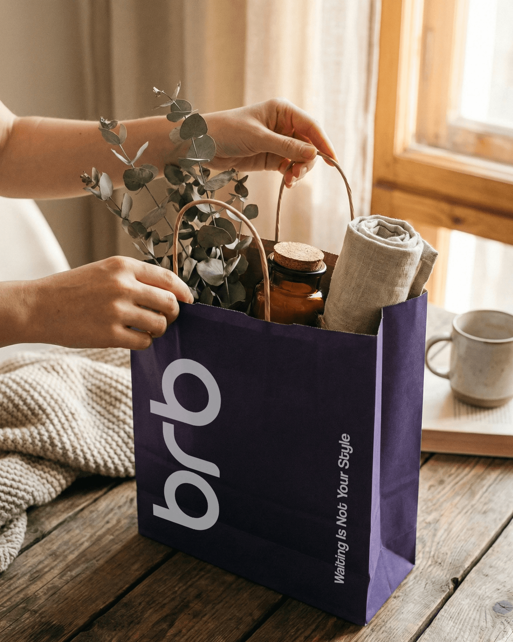 Hands opening a purple BRB bag on a table at home, with flowers and lifestyle items visible inside.