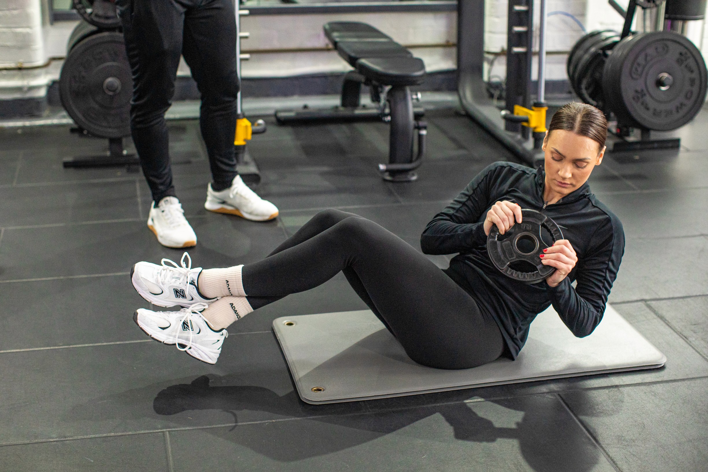 A woman doing weighted twist in the gym for compound exercise