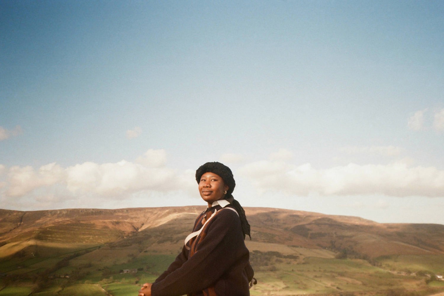 Stood atop a mountain, blue skies and hills below