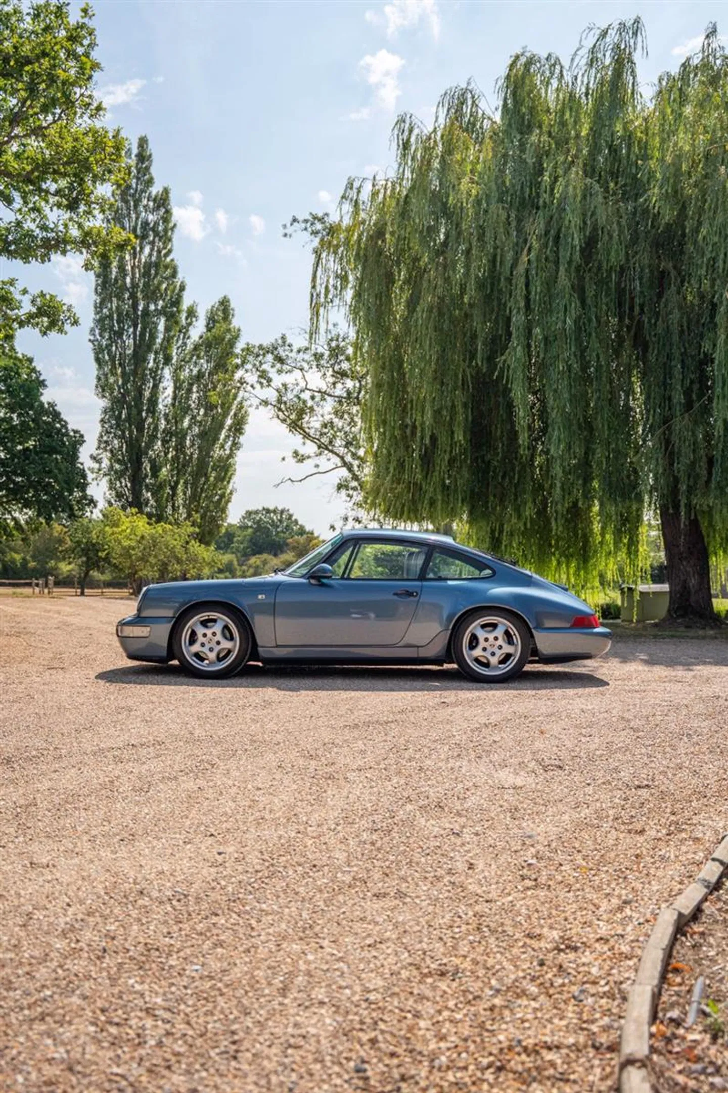 Side view of the 964 Carrera 2 on a gravel driveway with Cup 1 alloys
