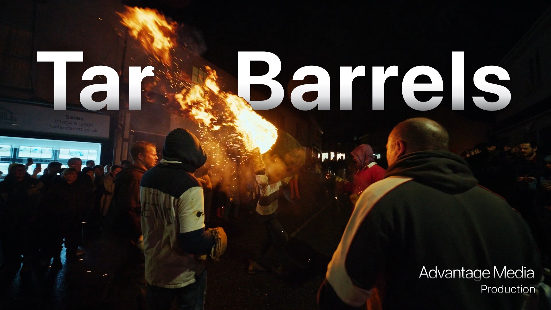 image showing a barrel on fire in middle of a crowd