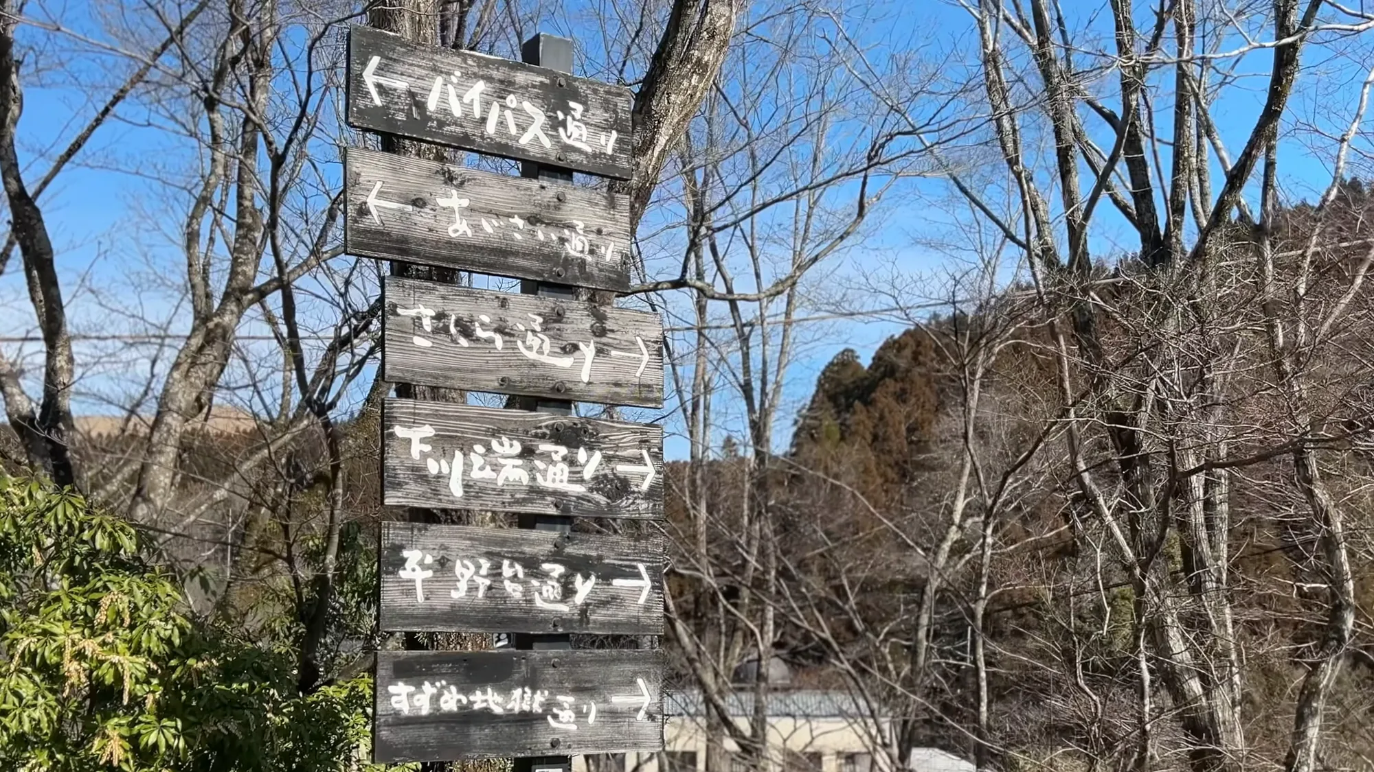 A multi-arm wooden signpost at Kurokawa Onsen pointing to several destinations
