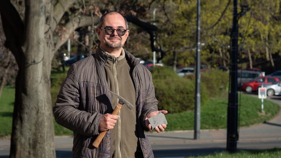 Scientist holding a fossil sample outdoors in Prague.