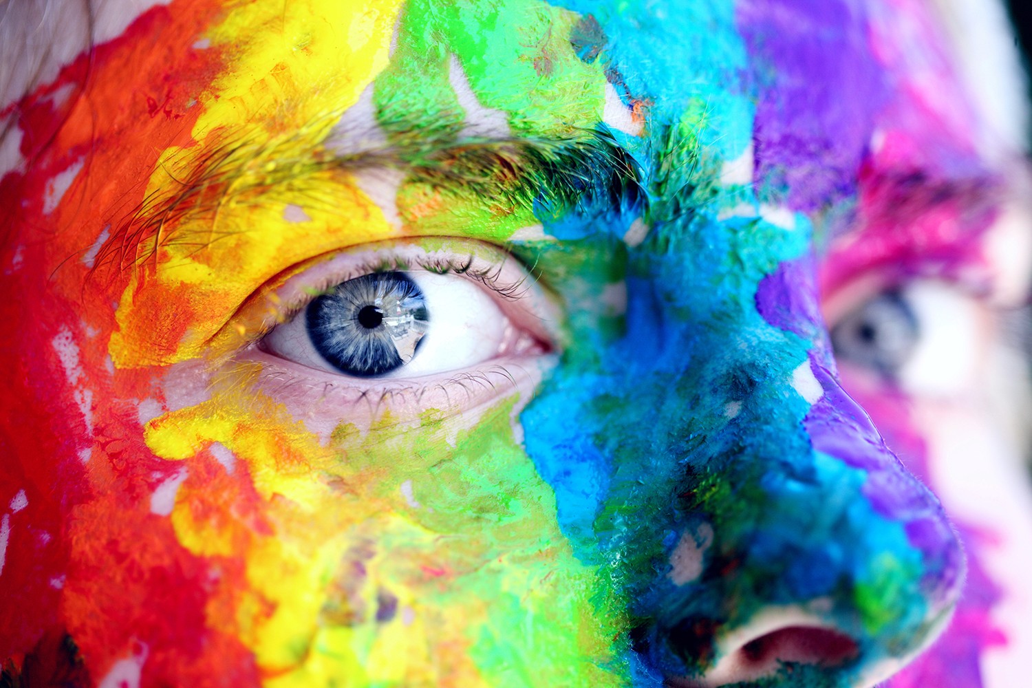 Face painted in the colours of the rainbow