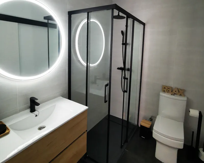 Elegantes modernes Badezimmer mit rundem Spiegel und Glasdusche in La Hipotenusa Tarifa