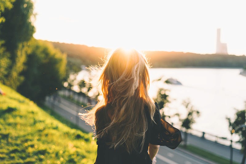 Ambigous photo of a young woman with blonde hair looking off into a sunset