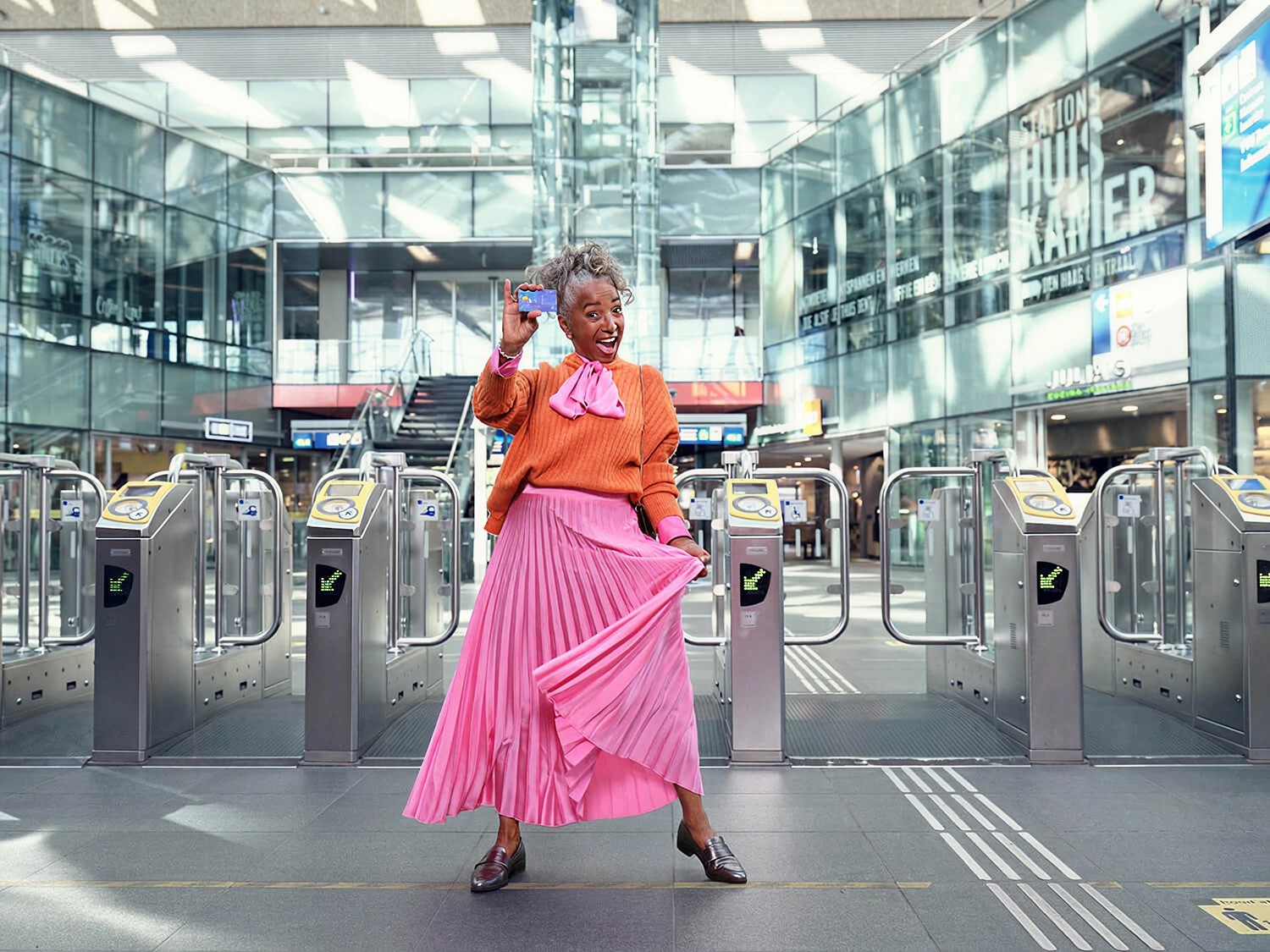 OVpay Commercial Still - Lady in vibrant magenta showing her debit card