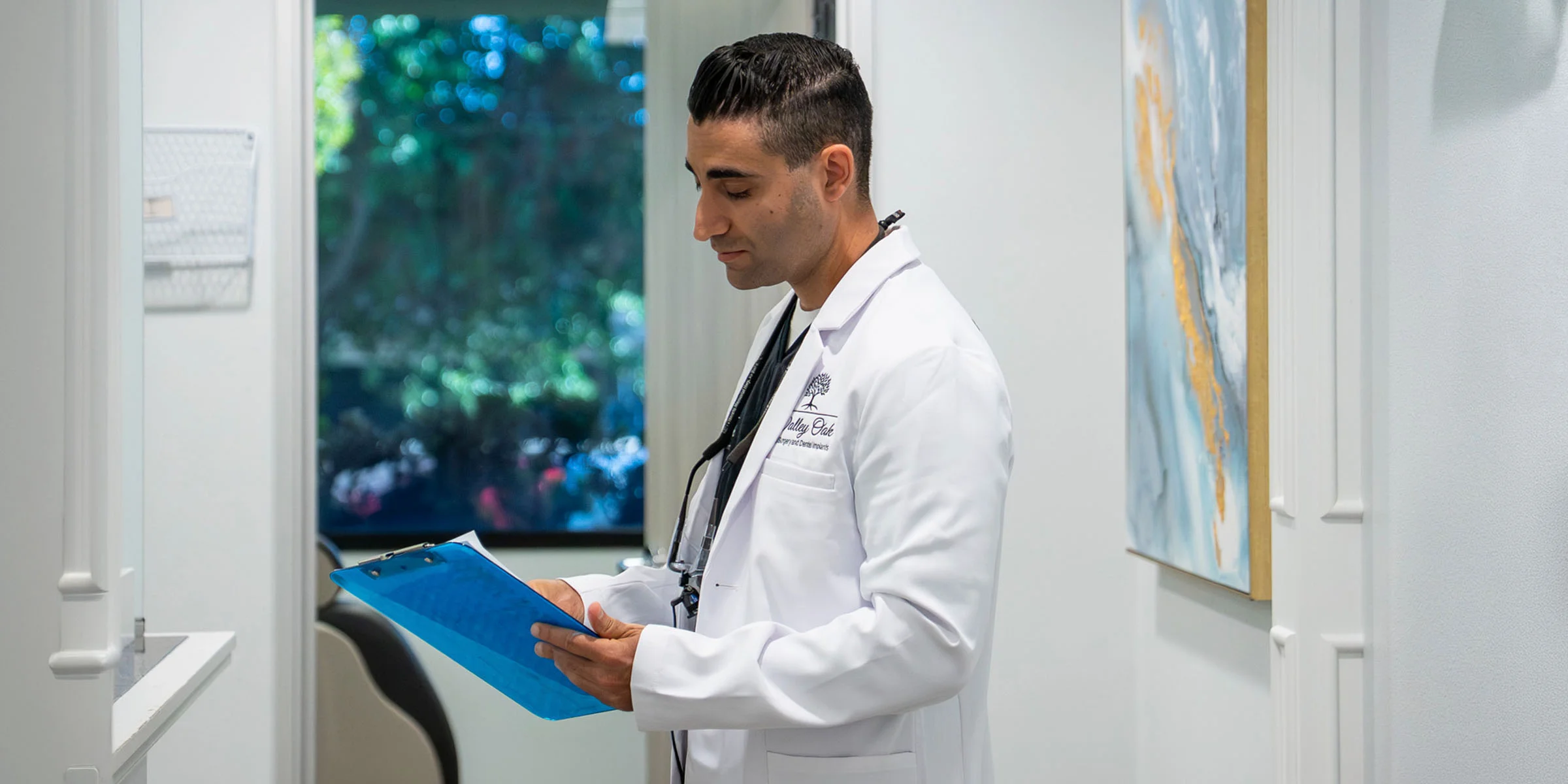 Dr. Justin Nassiri reviewing a patient chart at Valley Oak Oral Surgery in Fresno, CA