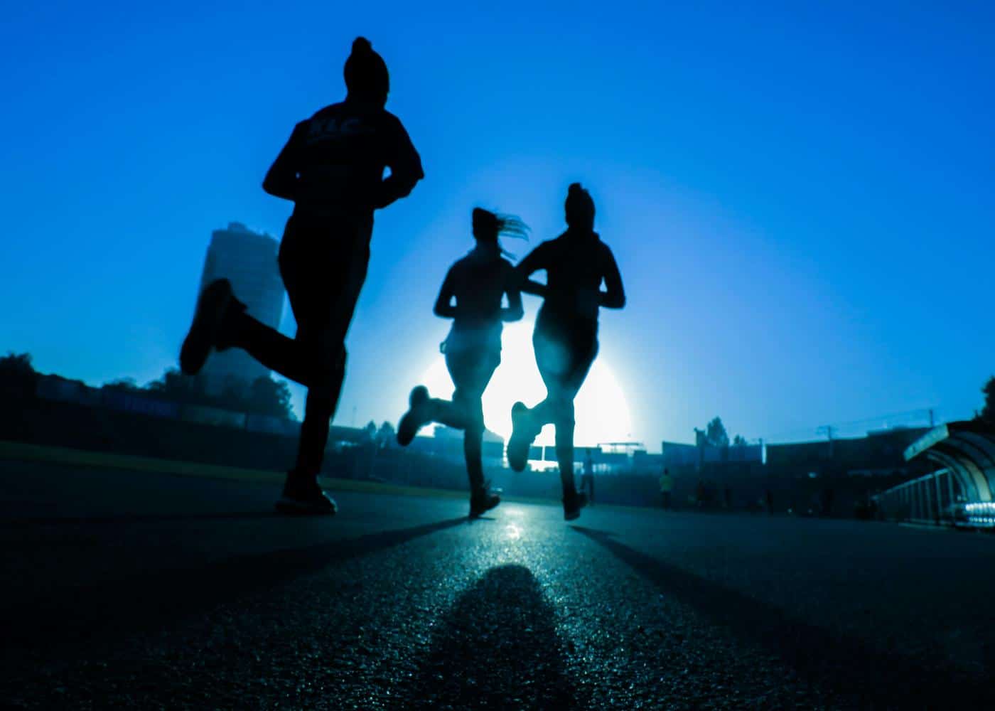 People running on a road against a bluebackground