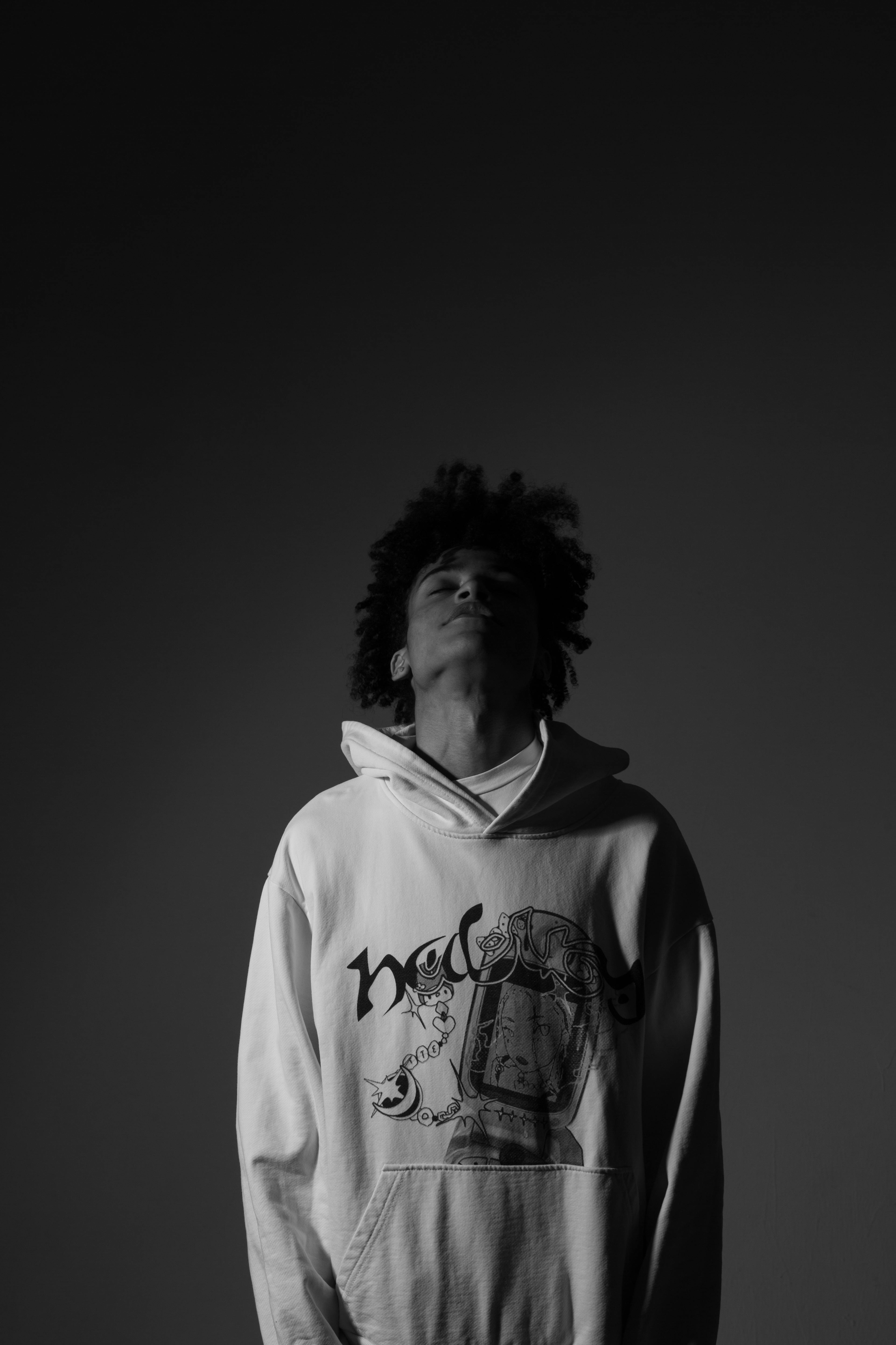 Grayscale Photo of a Man Standing with His Head Up