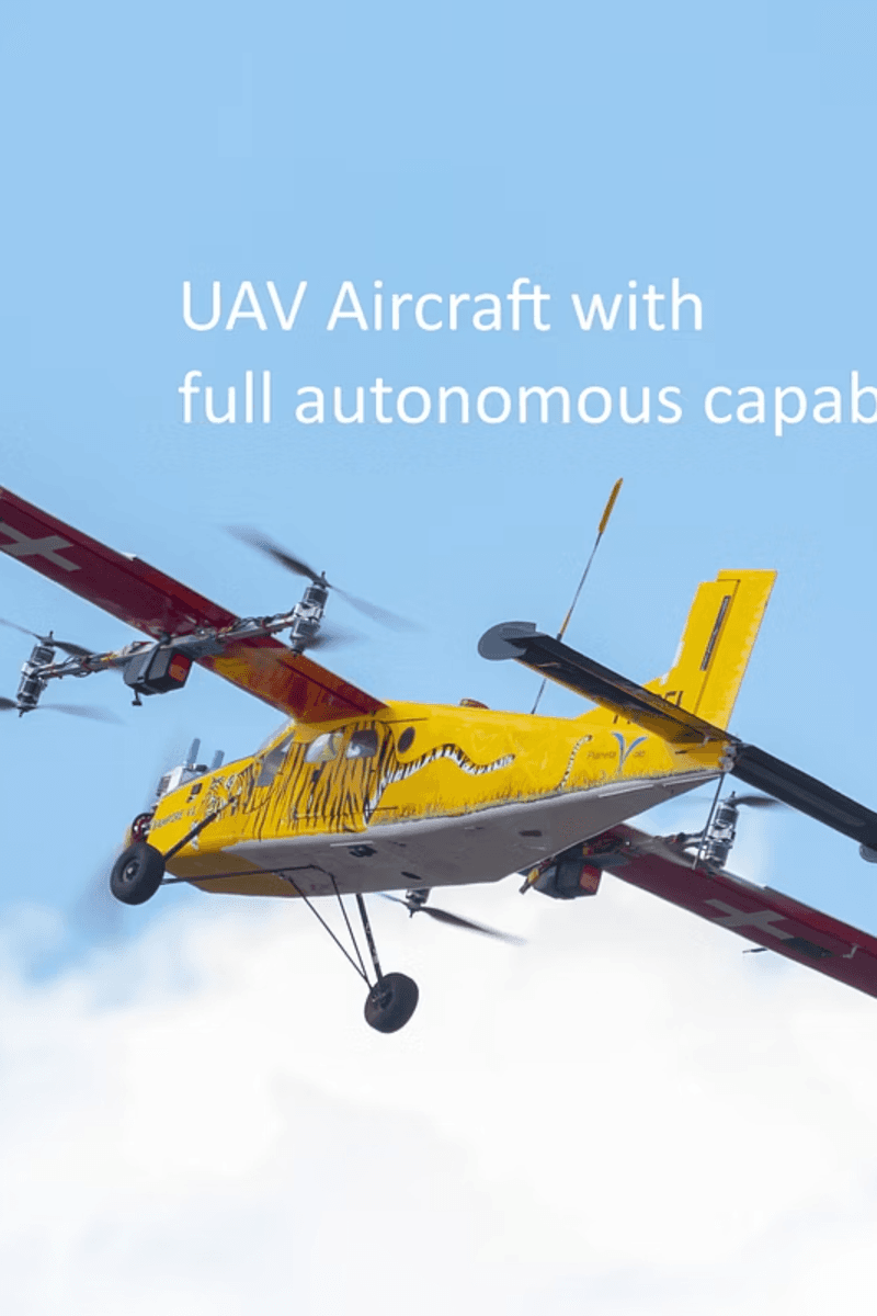 A yellow UAV aircraft with distinctive tiger-stripe markings flies alongside a red and green helicopter against a blue sky.