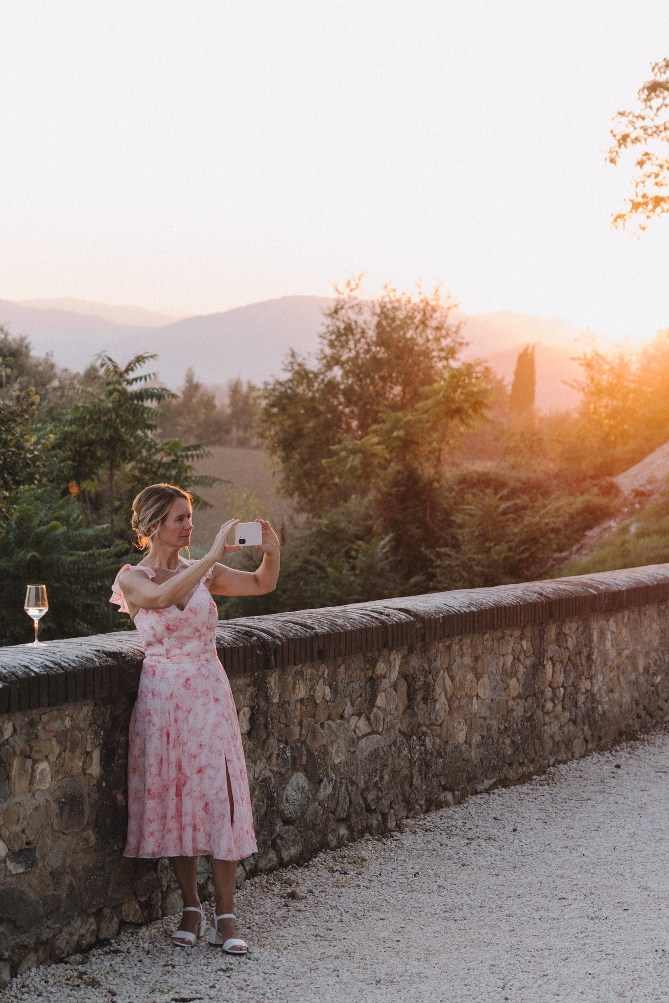 Sposa in abito rosa al tramonto al Castello di Tabiano, fotografa il paesaggio toscano con montagne sullo sfondo