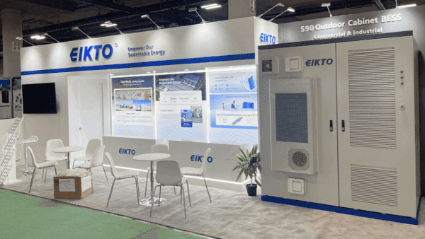 Angled view of a 20x30 NAB Show booth with operator-facing demo counter, media display screens, and organized visitor circulation