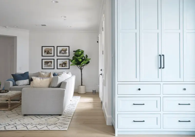 Wide shot showing the living room space and adjacent custom cabinetry, highlighting storage and design in the Dana Point Remodel. Photo by Todd Huge.