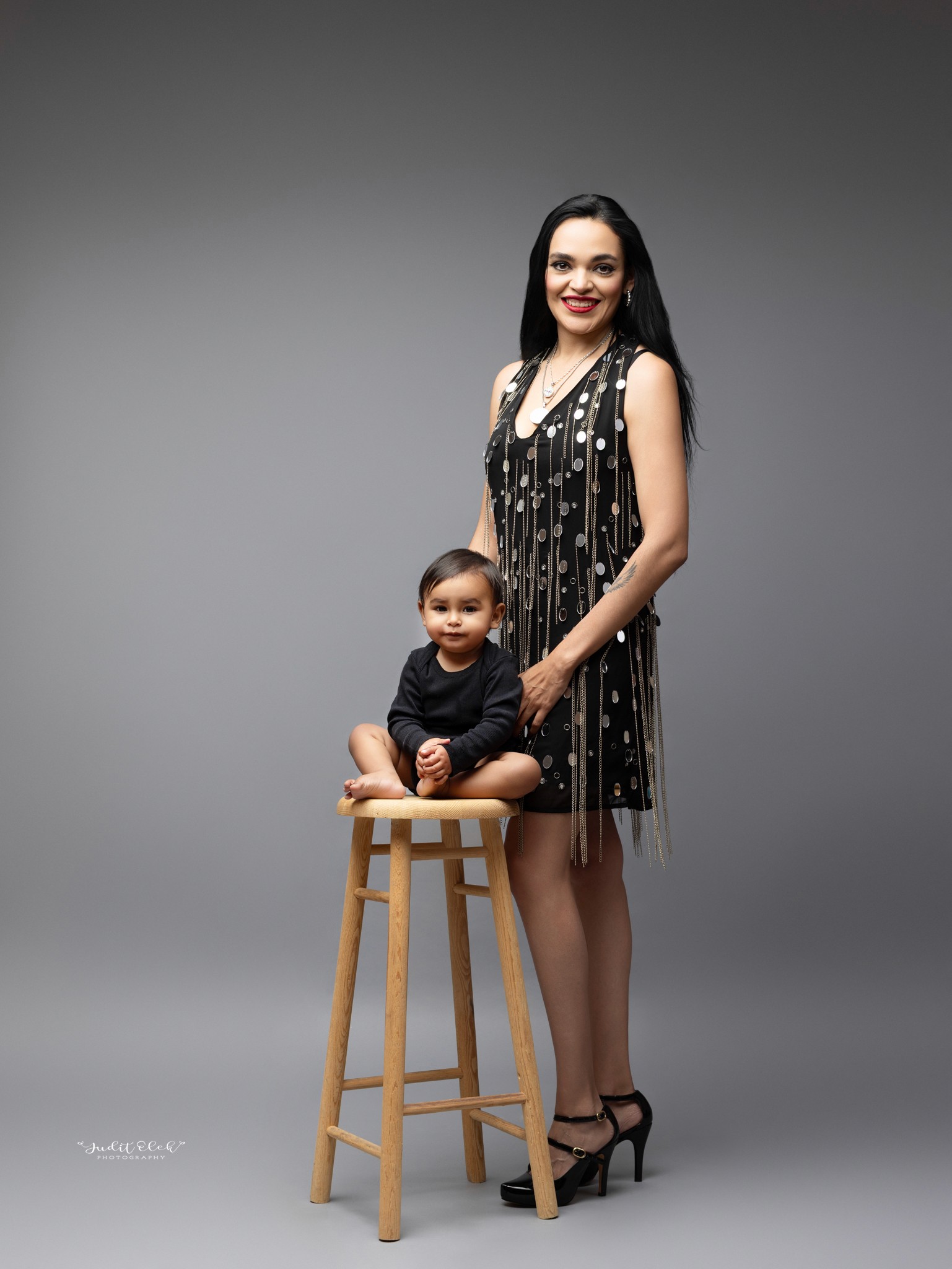 niño riendo con su mamá en una sesión de fotos en estudio fotográfico