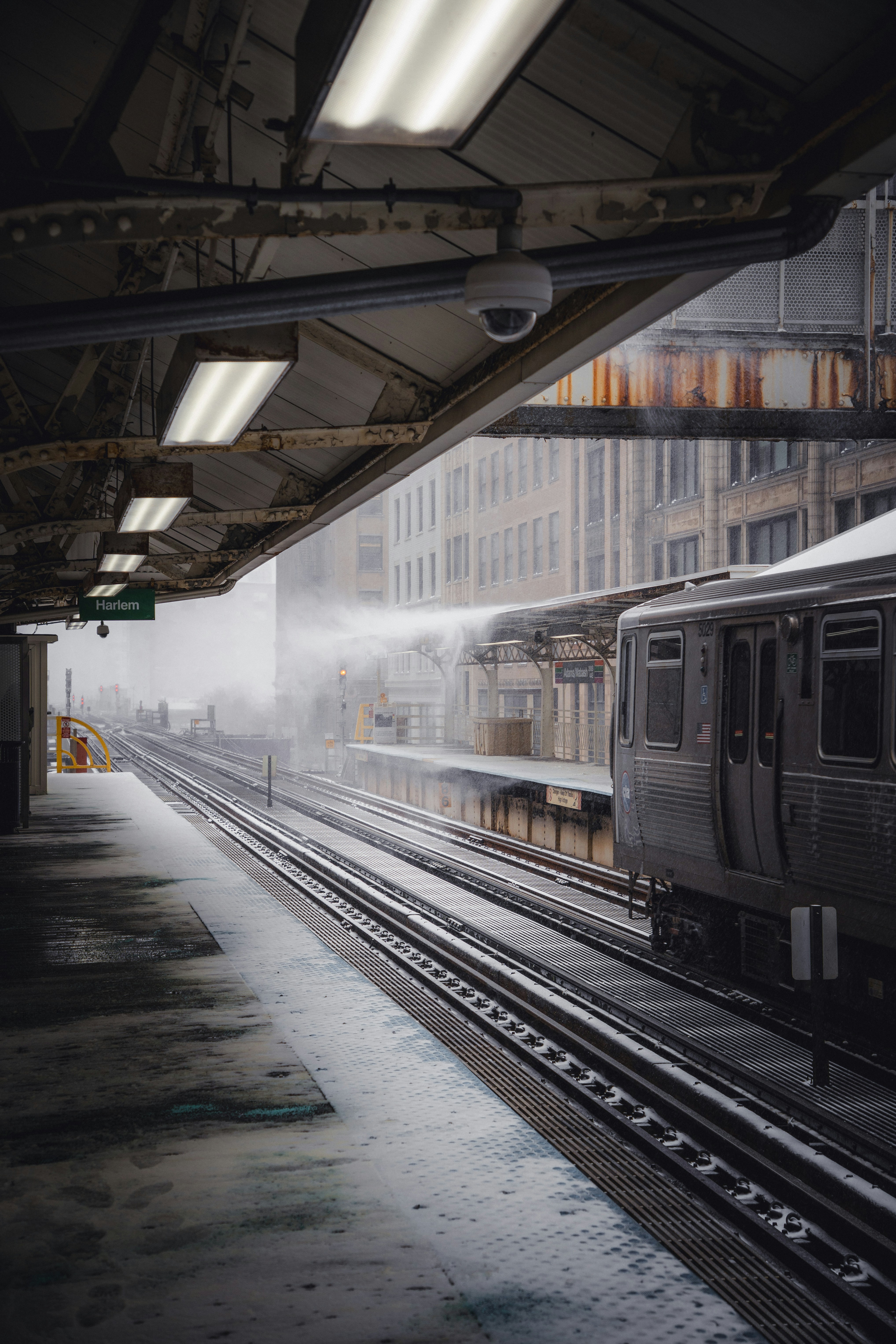 A train sits at a snowy station platform.