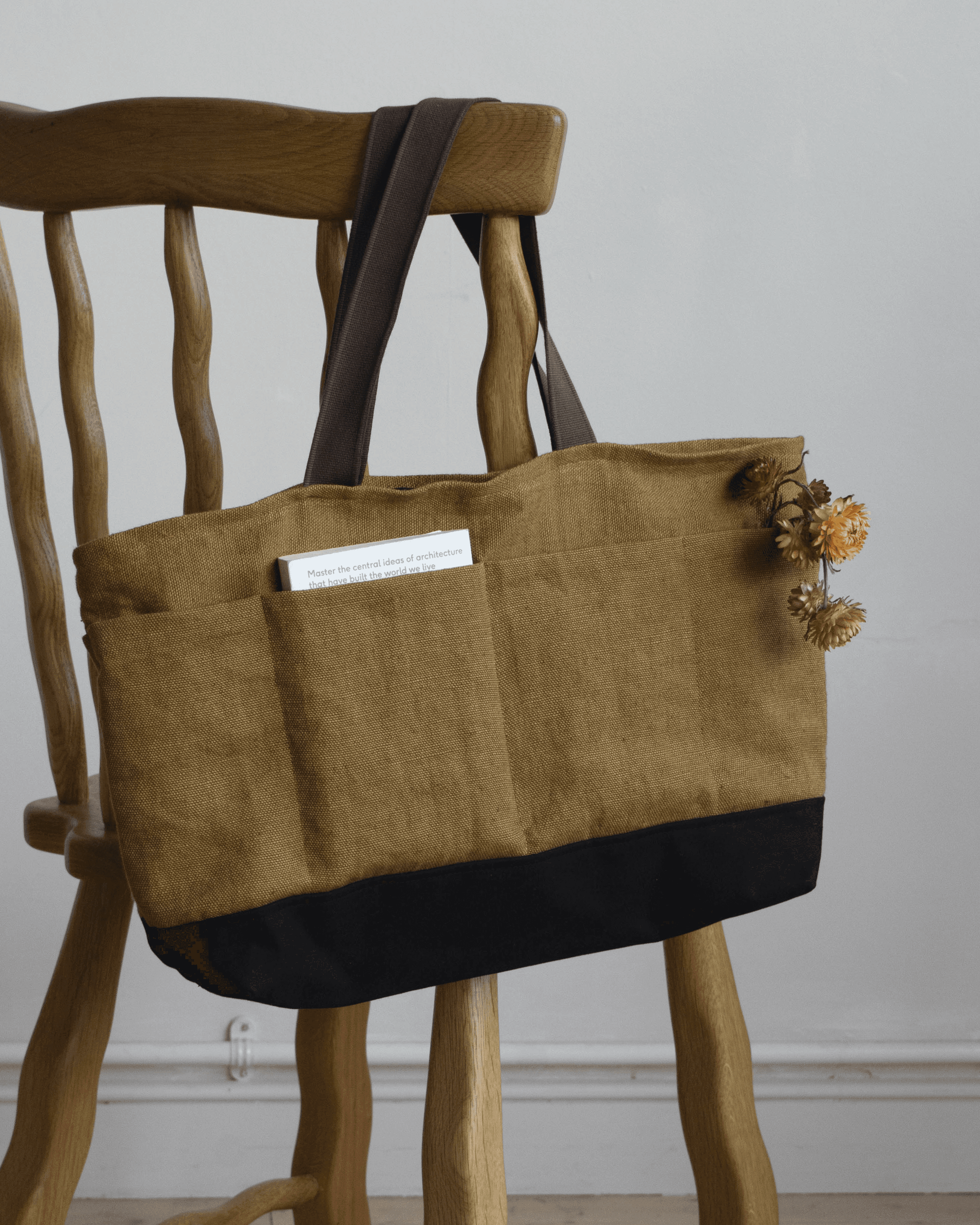 Limited edition Garden Tote from Wilkinson & Rivera in Belgian Linen hanging from chair with flowers and a book