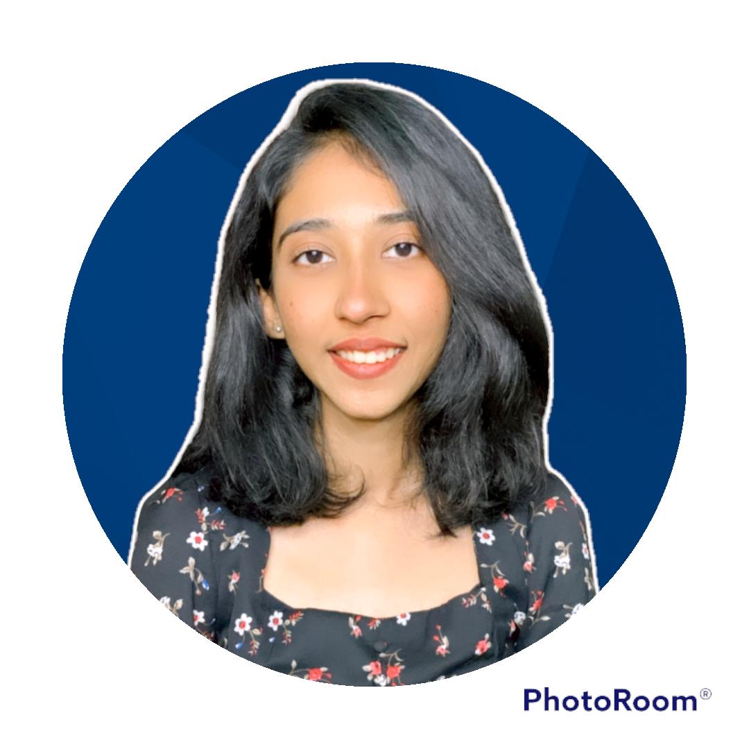 A person with short, curly blond hair wears a bright orange turtleneck sweater. The background is plain, creating a calm and focused portrait look.