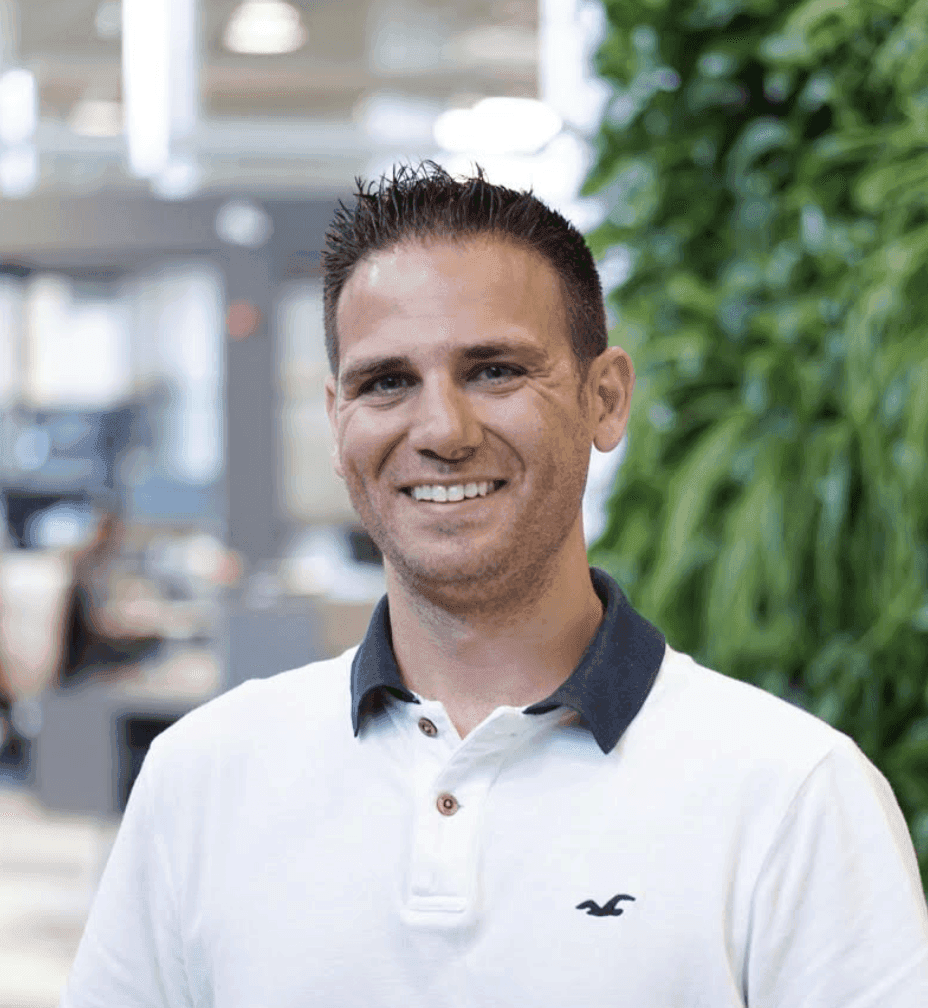 Photo of a man in a white polo shirt smiling