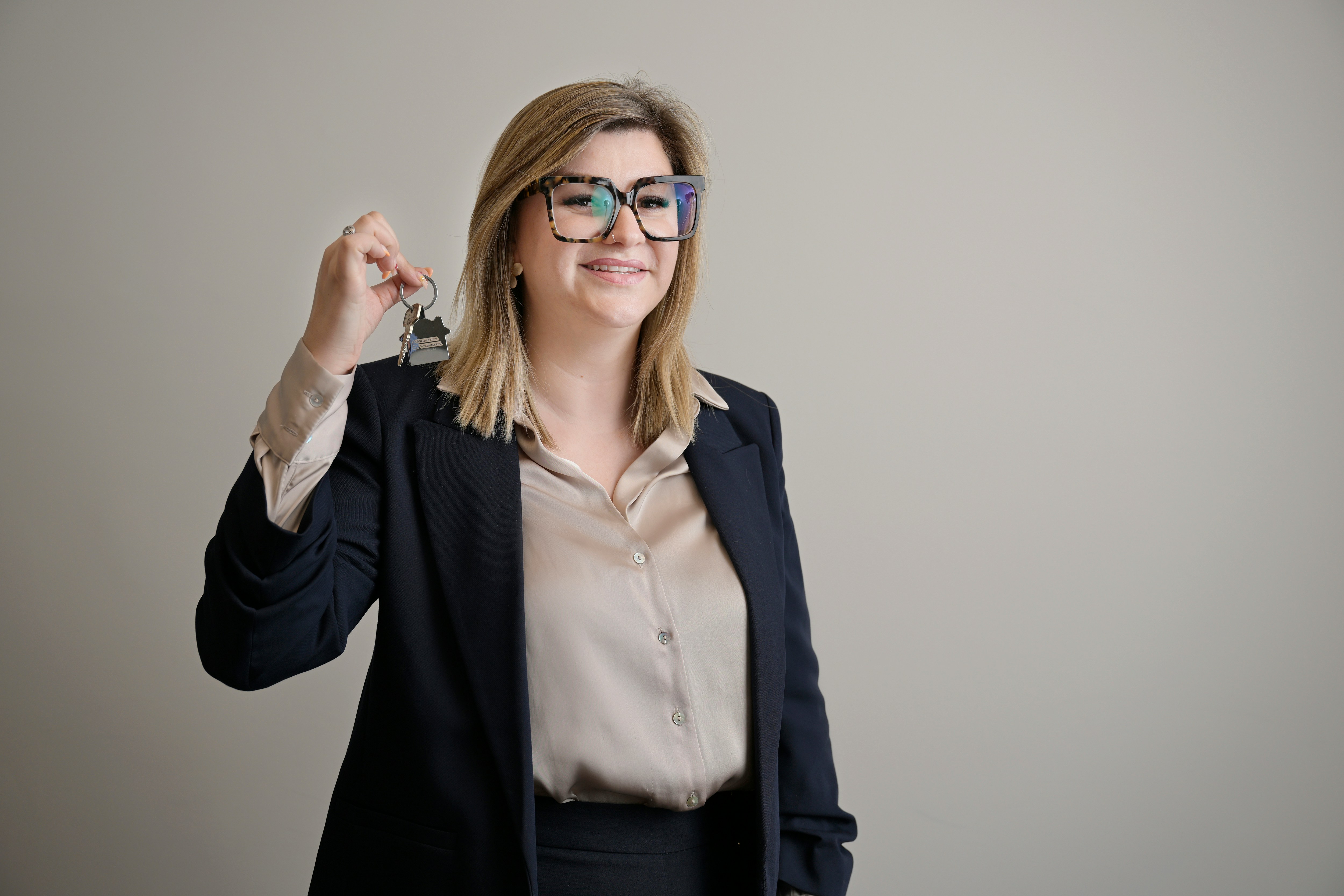 Real estate agent smiling and presenting a set of house keys