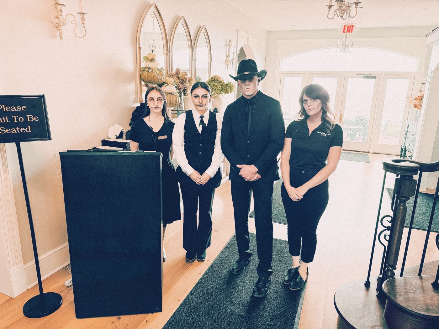 Four Vincent William staff in Halloween costumes at the host stand
