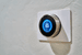 Wall-mounted smart thermostat displaying temperature and energy savings