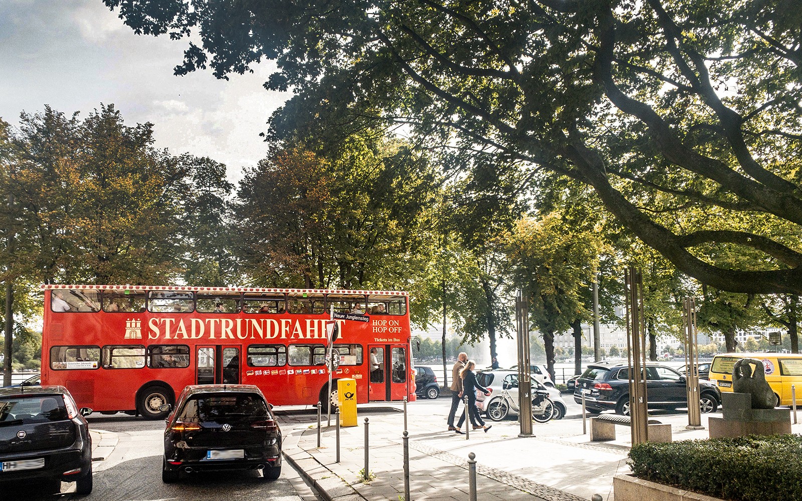 Roter Doppeldeckerbus auf einer Hamburger Straße in der Nähe der Alster, Deutschland.