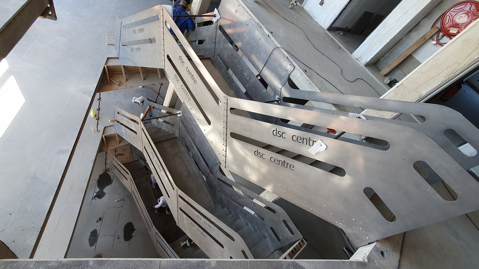 Modern minimalist white house with glass structure and black car in front.