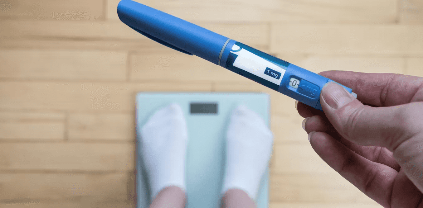 Person holding pen over scale - Who Should Not Take Semaglutide