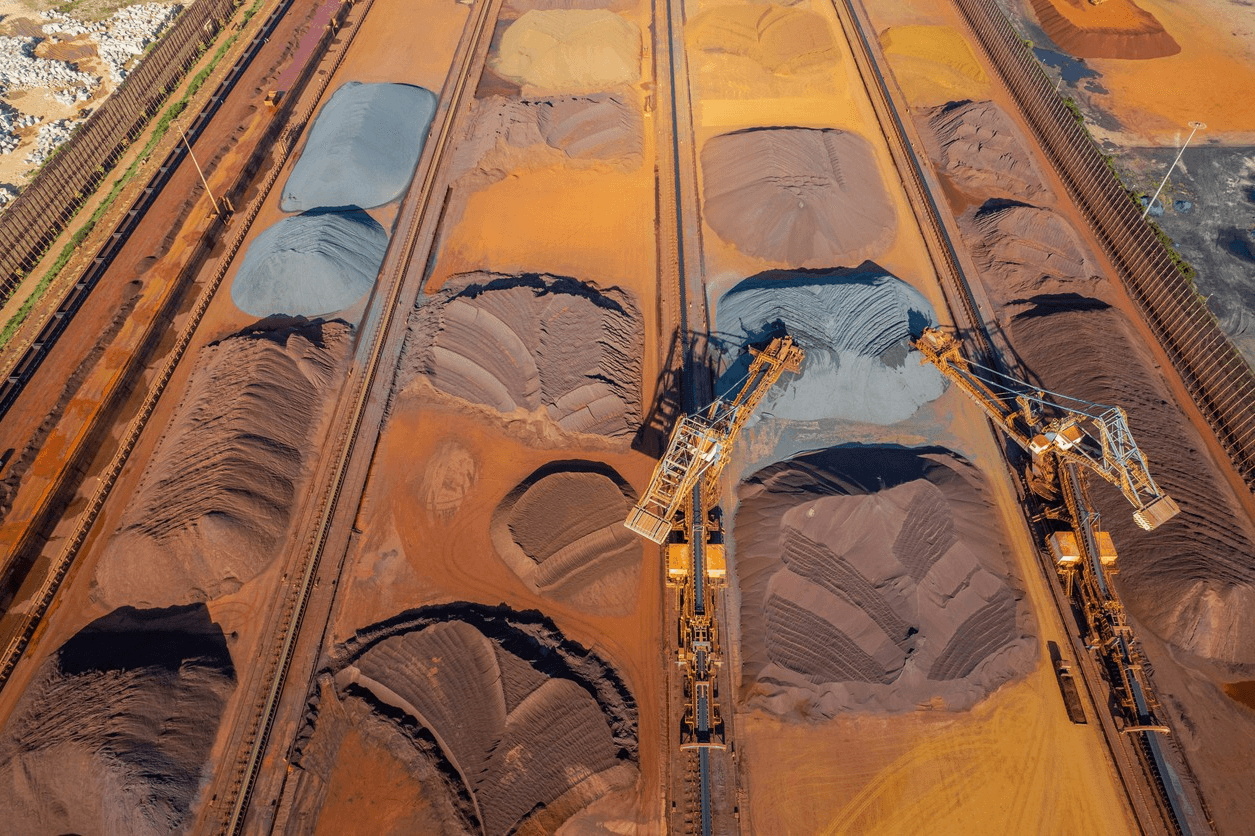 A top-down view of railway tracks and freight cars, showcasing earthy colors and textures.