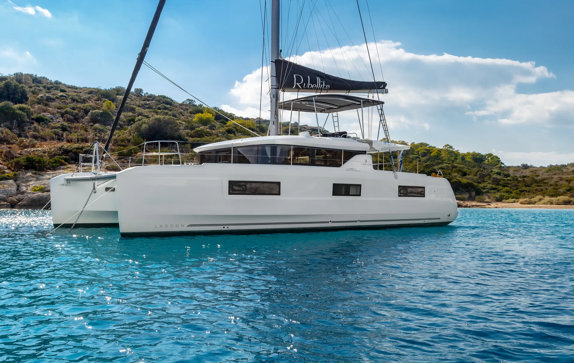 White Rock 36 speedboat with captain at helm cruising calm blue waters near Paros coastline with hills in background.
