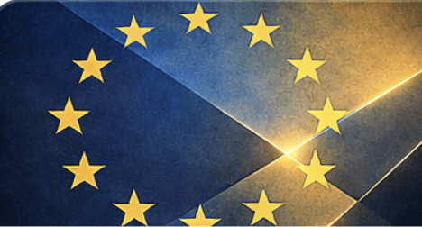 Aerial view of a winding road cutting through rocky terrain and sandy landscape.