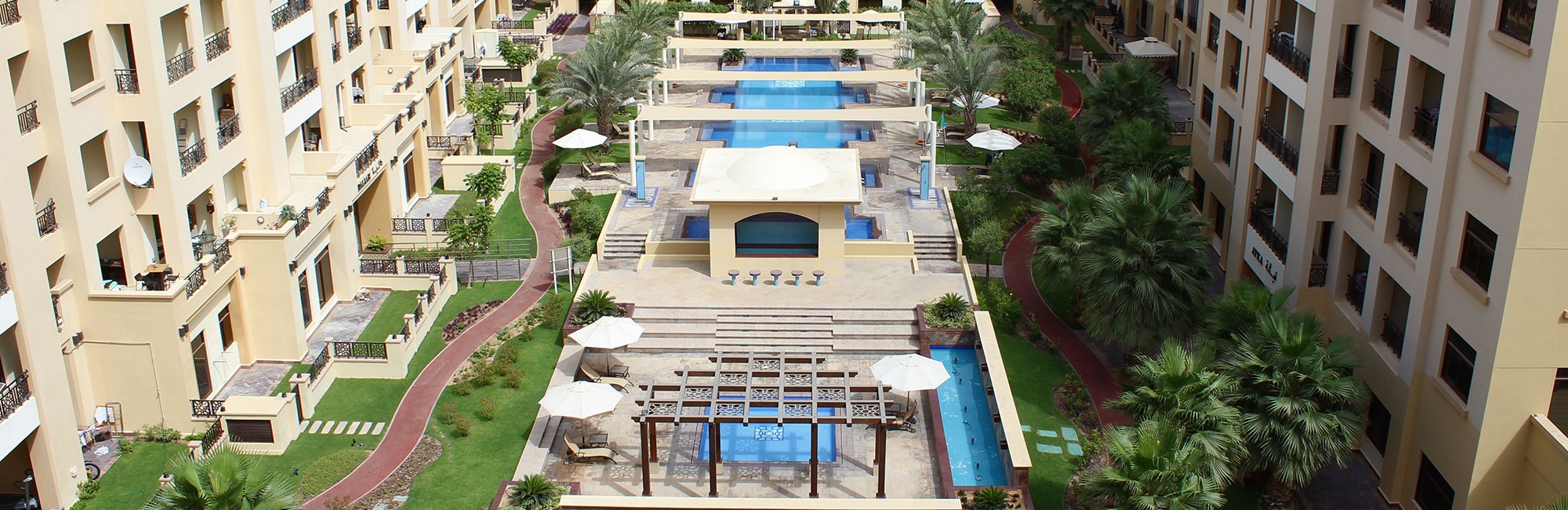 The Square by OMNIYAT includes a park with a fountain and playground, surrounded by homes in a residential setting.