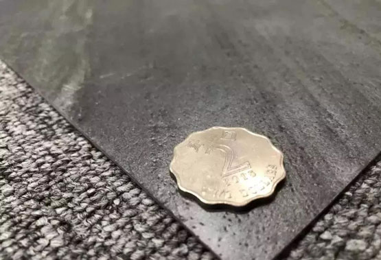 A coin placed next to a thin stone slab, emphasizing the thinness of the material.