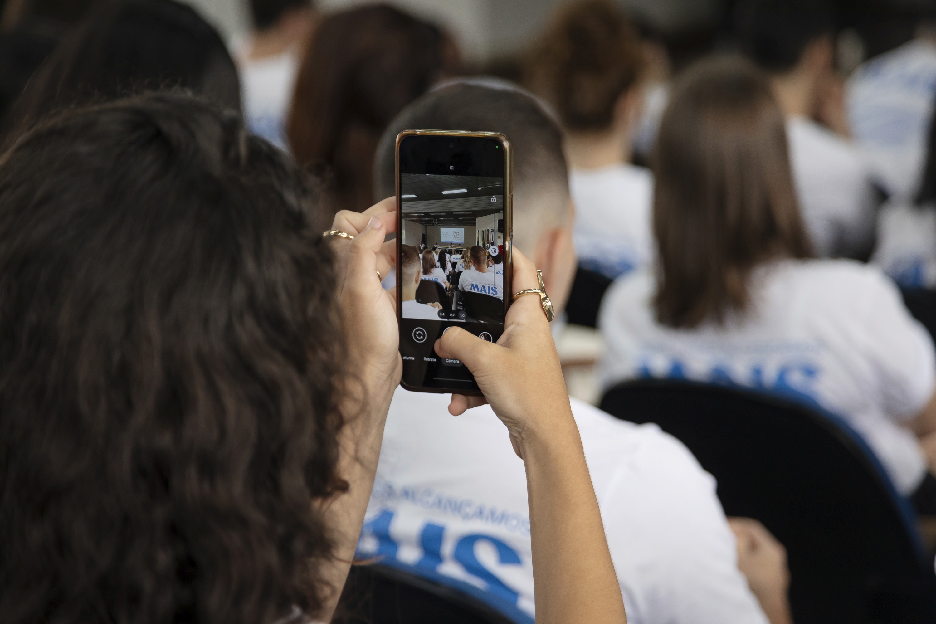 Mãos de um colaborador da Construct IN segurando um pedaço de papel com uma anotação manuscrita. A anotação é uma pergunta relacionada a uma campanha de marketing da Black Friday, demonstrando o engajamento e a troca de ideias em um evento interno da empresa.