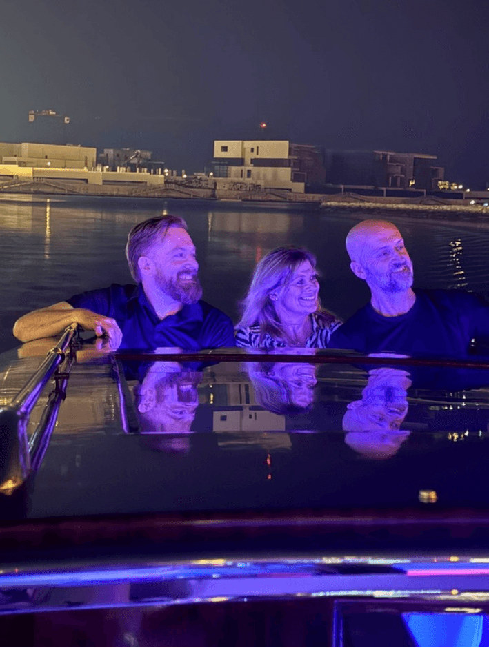 Happy tourists on an electric boat tour through The Pearl-Qatar canals, guided sightseeing experience in Doha.