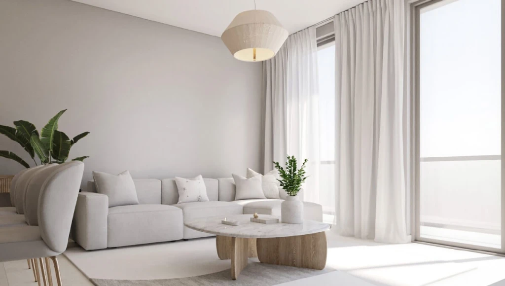 A modern living room featuring white furniture and a large window, showcasing the stylish design of Terrazzo Residences.