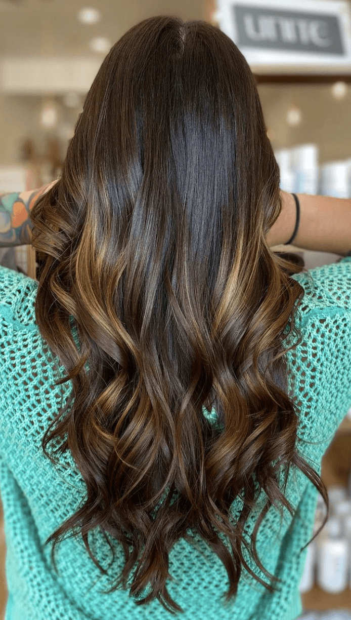 Dimensional brunette with copper tones at Del Sol Hair Studio in Huntington Beach