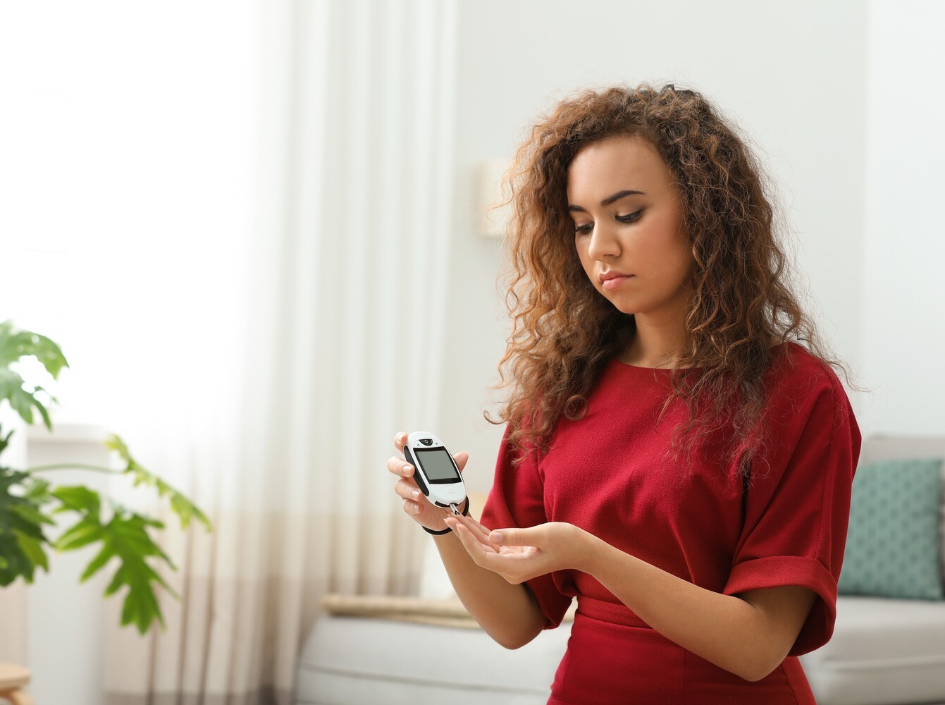 woman checking her blood sugar to monitor her condition while taking weight loss prescription pills and managing diabetes