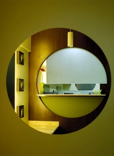 Nature-inspired preschool entrance with sculptural tree partitions and suspended green leaf ceiling panels.