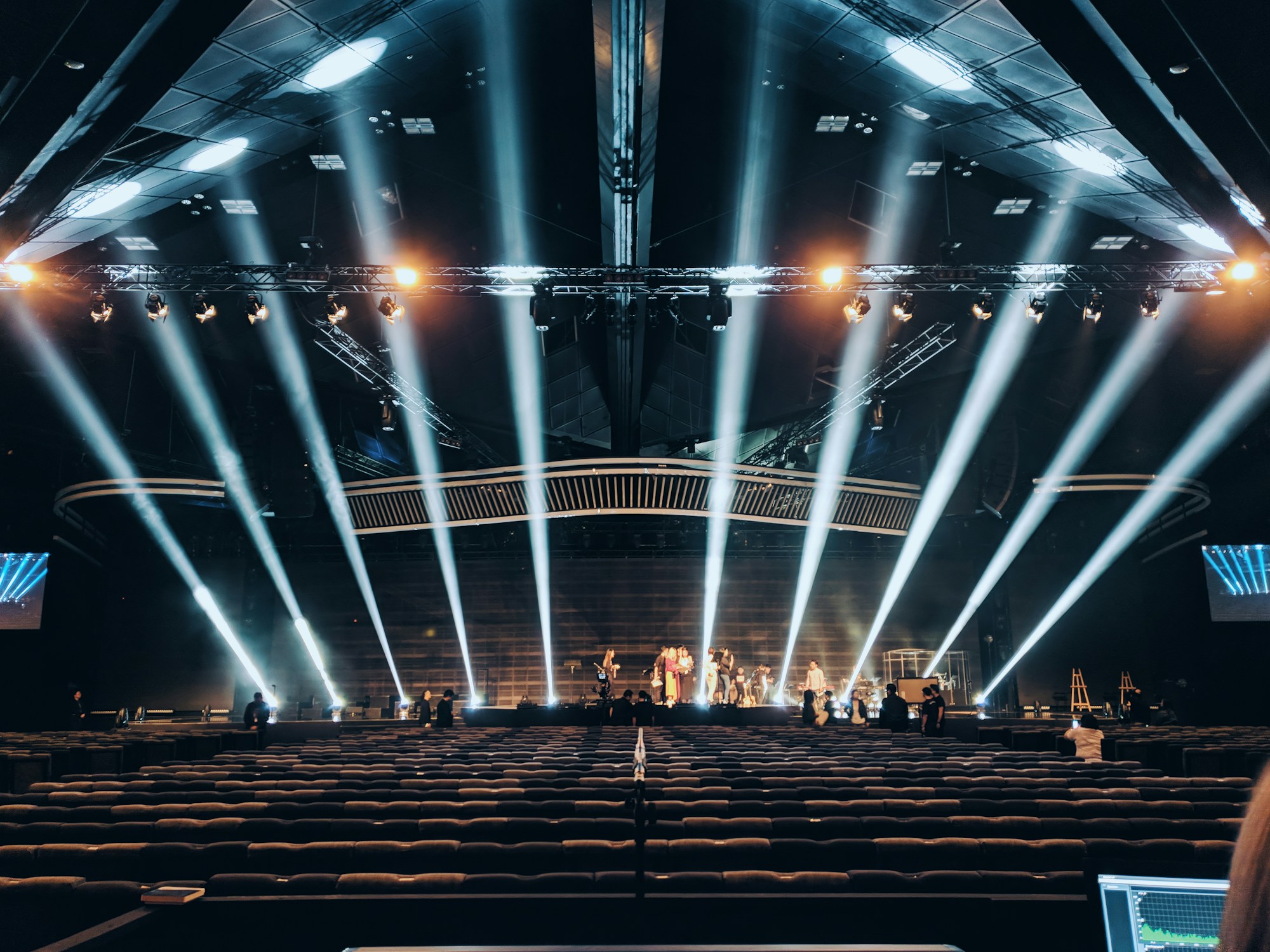 Large stage production with beam lighting during event rehearsal