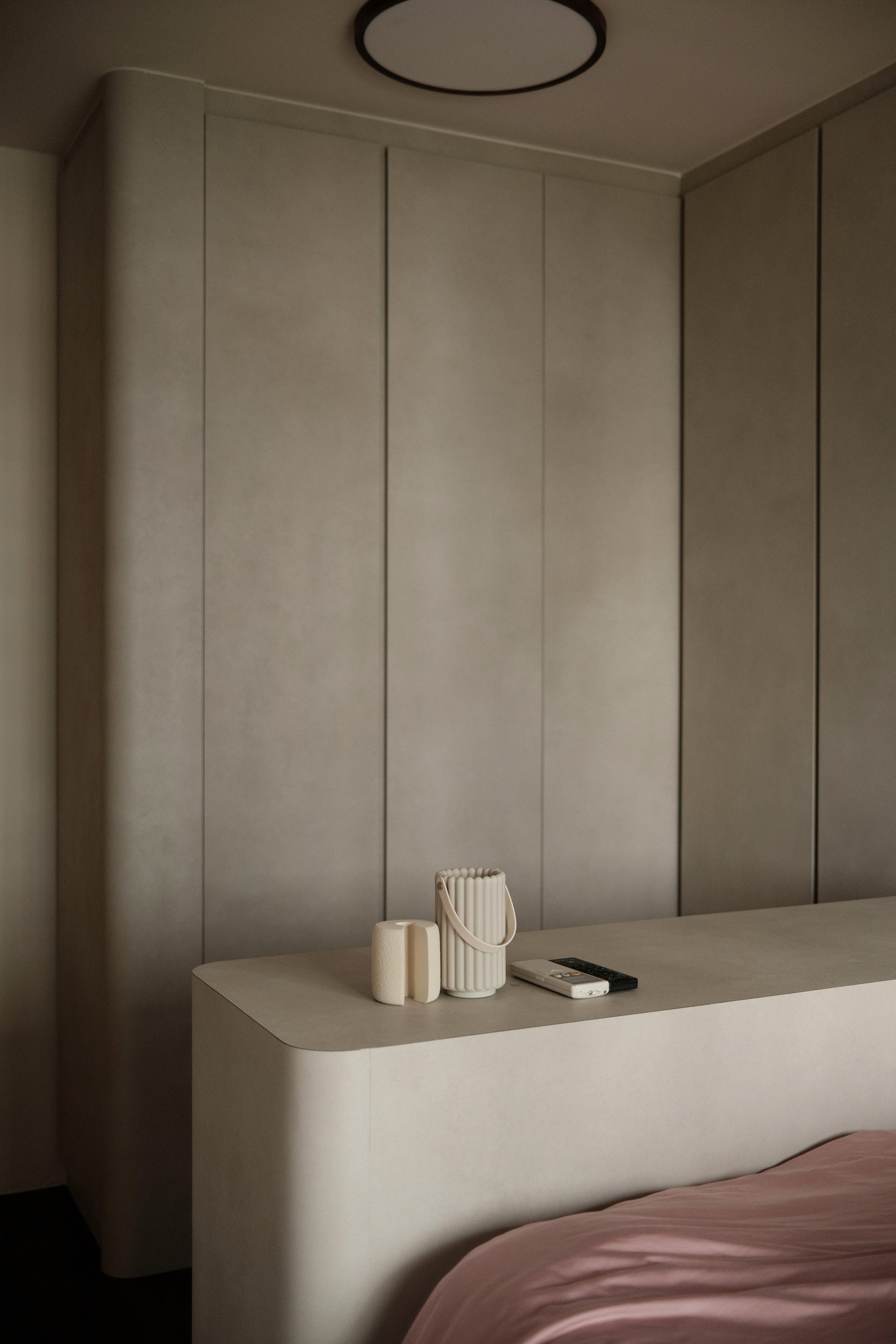 Seamless taupe built-ins define a serene, minimalist bedroom space.