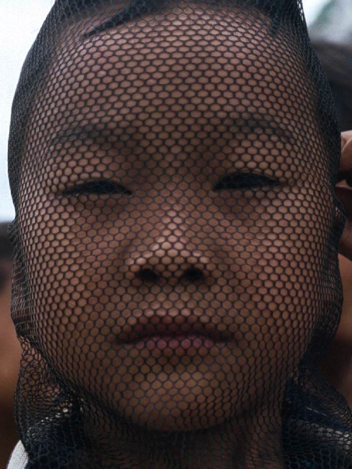 "Child's face behind a net"